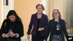 Sen. Elizabeth Warren, D-Mass., center, walks to the Senate chamber for the impeachment trial of President Donald Trump at the Capitol, Jan. 23, 2020, in Washington. 