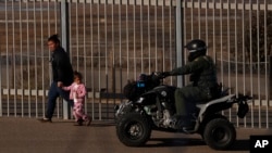 Archivo - Rachel Rivera, migrante hondureña de 19 años, y su hija, Charlot Andrea, de 3 años, caminan a lo largo de la valla fronteriza en San Ysidiro, California, tras entregarse a agentes de la Patrulla Fronteriza de EE.UU. el 4 de diciembre de 2018.