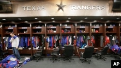 FILE - Texas Rangers pitcher Sam Dyson packs a bag in the locker room at the baseball park in Arlington, Texas, Oct. 11, 2016. Major U.S. sports leagues are closing access to locker rooms and clubhouses to all non-essential personnel.