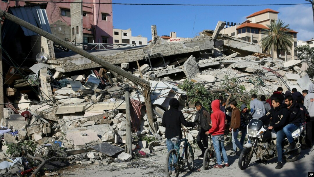 Warga memeriksa kerusakan pada gedung bertingkat milik perusahaan asuransi yang terafiliasi Hamas, yang rusak setelah serangan udara Israel, di Gaza, Selasa, 26 Maret 2019.