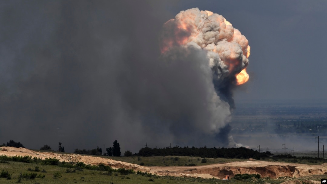 Gumpalan asap mengepul di atas depot amunisi tempat ledakan terjadi di fasilitas tersebut di distrik Kirovsky di Krimea, Rabu, 19 Juli 2023. (Foto: via AP)