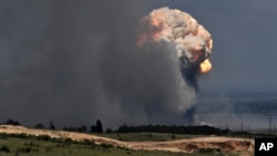 Gumpalan asap mengepul di atas depot amunisi tempat ledakan terjadi di fasilitas tersebut di distrik Kirovsky di Krimea, Rabu, 19 Juli 2023. (Foto: via AP)