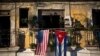 FILE - U.S. and Cuban flags hang from a balcony in Old Havana, Cuba, Dec. 19, 2014.