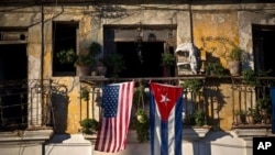 FILE - U.S. and Cuban flags hang from a balcony in Old Havana, Cuba, December 19, 2014.