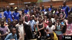 Girls trying out for a possible future in Malawi's National Female Football Team pose with their coaches during a talent search in Zomba, Malawi. (L. Masina/VOA)