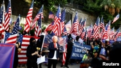 A protester wearing a mask depicting U.S. President Donald Trump gestures during a "March of Gratitude to the US" event near the U.S. Consulate in Hong Kong, China December 1, 2019.