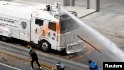 A police water cannon disperses demonstrators during an opposition rally in Caracas, Venezuela, April 6, 2017. 