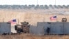 FILE - U.S. troops are seen behind the Turkish border walls in northern Syria, Sept. 8, 2019.