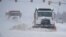 Plows drive down a road during a winter storm in Oklahoma City, Oklahoma, Feb. 14, 2021.