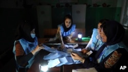 FILE - Afghan election workers count ballots in the presidential elections at a polling station in Kabul, Afghanistan, Sept. 28, 2019.