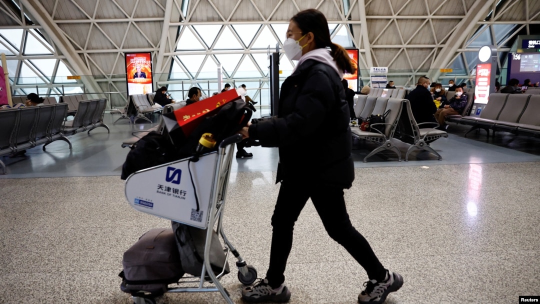 Arhiva - Putnica gura kolica za prtljag na međunarodnom aerodromu Čengdu Šuangliju usred talasa infekcija Kovida 19, u Čengduu, pokrajina Sečuan, Kina, 30. decembra 2022.
