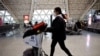 Seorang pelancong mendorong kereta bagasi di Bandara Internasional Shuangliu Chengdu di tengah gelombang infeksi COVID-19, di Chengdu, Provinsi Sichuan, China 30 Desember 2022. (Foto: REUTERS/Tingshu Wang)