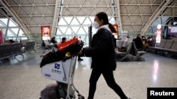 中国成都双流国际机场，旅客又带起了口罩。