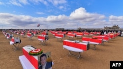 FILE - A mass funeral is held for Yazidi victims of the Islamic State group, in the northern Iraqi village of Kojo in Sinjar district, Feb. 6, 2021. The remains of 104 Yazidi victims have been returned, six years after IS swept through northern Iraq. 