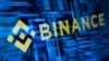 示意图：加密货币交易所币安的标志和黑客代码。