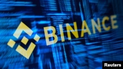 示意图：加密货币交易所币安的标志和黑客代码。