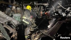Vatrogasci rade na mjestu skladišta koje je teško oštećeno tokom napada ruskog drona 21. decembra 2023. (Pres služba Državne službe za vanredne situacije Ukrajine u Kijevskoj oblasti/Handout preko REUTERS)