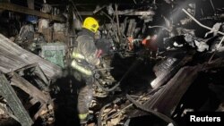 Firefighters work at a site of a warehouse heavily damaged during a Russian drone strike, amid Russia's attack on Ukraine, in Kyiv region, Ukraine, released Dec. 21, 2023. (Press service of the State Emergency Service of Ukraine in Kyiv region/Handout via REUTERS)