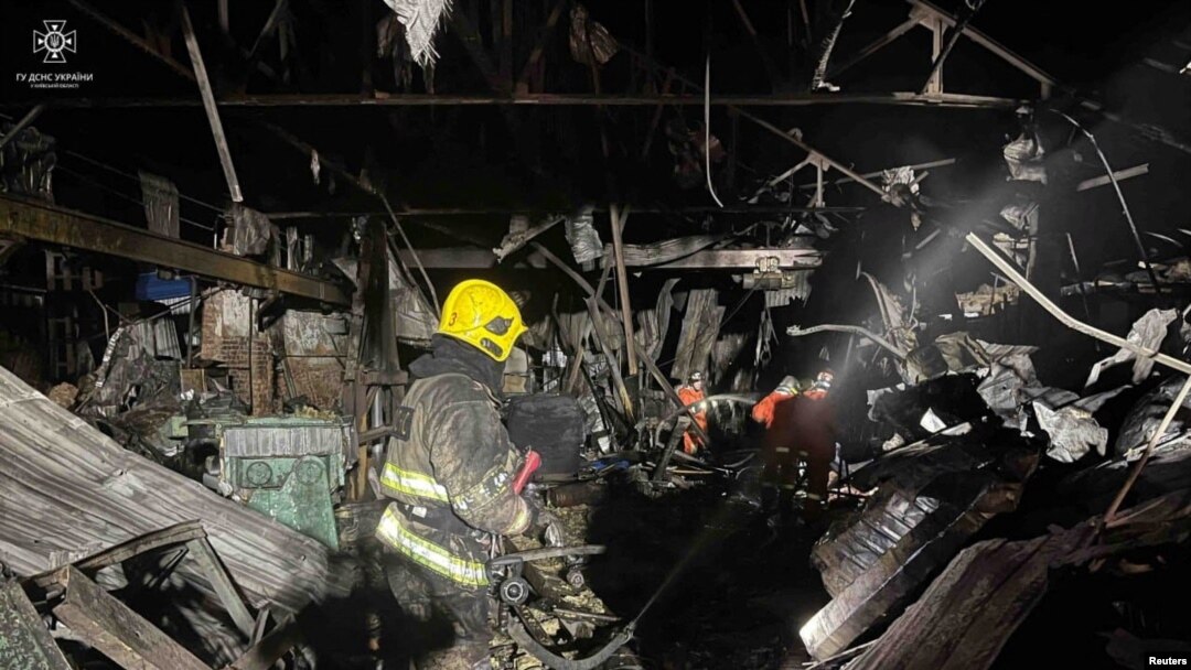 Petugas pemadam kebakaran bekerja di lokasi gudang yang rusak berat akibat serangan pesawat tak berawak Rusia, di wilayah Kyiv, Ukraina, dirilis 21 Desember 2023.(Layanan pers Layanan Darurat Negara Ukraina di wilayah Kyiv/Handout via REUTERS)