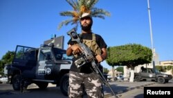 A member of the Security personnel affiliated with the Ministry of Interior secures the street after yesterday's clashes between armed factions in Tripoli, Libya, August 16, 2023.