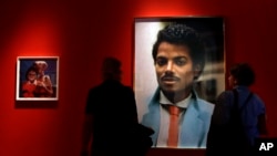 Visitors look at an artwork by Hank Willis Thomas on display at the Michael Jackson: On The Wall exhibition at the National Portrait Gallery in London, June 27, 2018.