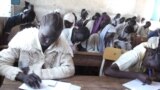 FILE - South Sudanese children sit an exam in a high school in Aweil.