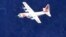 FILE - A U.S. Coast Guard C-130 aircraft flies in a search pattern in waters off the southwest coast of Eleuthera in the Bahamas, Aug. 2, 2003.