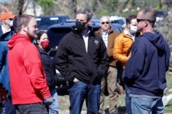 Tennessee Gov. Bill Lee, center, talks with residents as he visits a storm-damaged area in Chattanooga, Tenn., April 14, 2020.