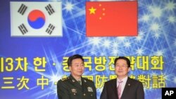 Menteri Pertahanan Korea Selatan Baek Seung-Joo (kanan) berjabat tangan dengan deputi Kepala Staf Militer China Mayjen Wang Guanzhong di Seoul, Korea Selatan (28/11).