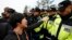 A family member of a passenger missing after the South Korean ferry capsized demonstrates in front of police during a protest in Jindo on April 20, 2014. 