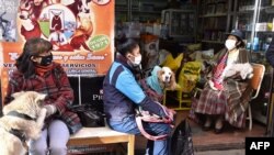Bolivianos usan mascarilla mientras esperan fuera de una clínica veterinaria después de que el gobierno relajó la estricta cuarentena de más de dos meses debido al nuevo coronavirus.