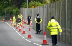Police officers stand guard outside a security gate around Tregenna Castle in Carbis Bay, Cornwall, England, June 9, 2021.