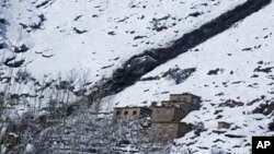 Batu-batu dari puncak gunung terlihat di dekat longsoran salju di distrik Khanj provinsi Panjshir, utara Kabul, Afghanistan (26/2).