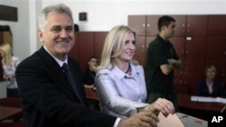 Tokoh oposisi Tomislav Nikolic (kiri) bersama isterinya, Dragica saat memasukkan kartu suara di TPS Beograd, Serbia (20/5). Nikolic mengalahkan Presiden Boris Tadic dalam pilpres hari Minggu.