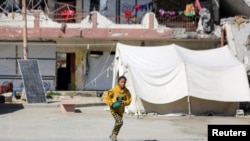 Una niña palestina desplazada corre en un refugio convertido en escuela, en medio del actual conflicto entre Israel y Hamas, en la ciudad de Gaza, el 24 de octubre de 2024. REUTERS