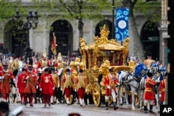 El rey Carlos III y la reina Camila se dirigen al Palacio de Buckingham luego de su coronación en Londres el sábado 6 de mayo de 2023. (AP/Jon Super)