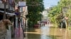 A youth sits on a roof overlooking a flooded street due to a swollen river caused by heavy rains and induced by Super Typhoon Man-yi in Tuguegarao City, Cagayan province on November 19, 2024.