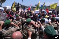 FILE - Hezbollah supporters scuffle with Lebanese army soldiers while protesting the visit by Gen. Frank McKenzie, the head of U.S. Central Command, outside the Rafik Hariri International Airport in Beirut, Lebanon, July 8, 2020.