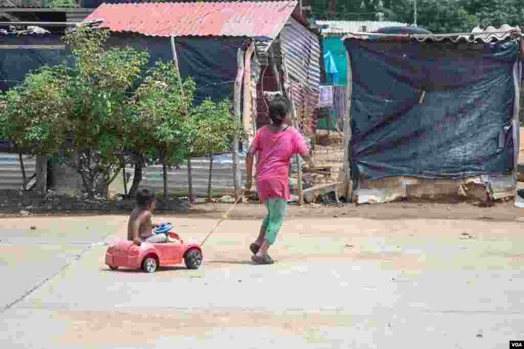 Una ni&#241;a jala en su carrito a su hermano en La Pista, una zona cerca de la frontera colombo-venezolana en donde familias venezolanas viven bajo extremas condiciones de pobreza.