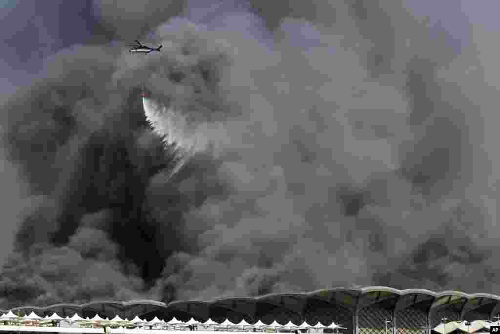 A firefighting helicopter sprays water on a fire at a train station, in Jiddah, Saudi Arabia.