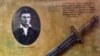 FILE - A photo of abolitionist John Brown is seen at the John Brown Museum in Osawatomie, Kansas, May 17, 2000, with part a broadsword similar to ones used by Brown and his sons.