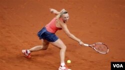 Caroline Wozniacki mengembalikan bola petenis Jerman Andrea Petkovic dalam babak perempat final Porsche Grand Prix di Stuttgart hari Kamis (21/4). Wozniacki menang 6-4, 6-1.