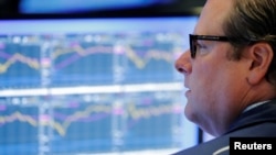 FILE - A trader works on the floor of the New York Stock Exchange shortly after the opening bell in New York, July 31, 2018. 