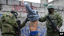 Soldados detienen brevemente a un joven para comprobar si tiene tatuajes relacionados con pandillas mientras patrullan el lado sur de Quito, en medio de la ola de violencia en Ecuador, el 12 de enero de 2024. 