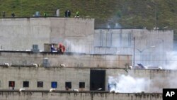 ARCHIVO - El gas lacrimógeno se eleva desde partes de la cárcel de Turi donde estalló un motín de reclusos en Cuenca, Ecuador, en febrero de 2021.
