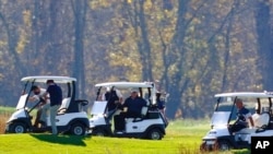 President Donald Trump, in center cart, participates in a round of golf at the Trump National Golf Course, Nov. 7, 2020, in Sterling, Va.