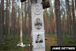 Krasny Bor means the “Beautiful Grove” and but for white wooden markers identifying pits where the killed were buried under tall swaying pine trees it would be. (J. Dettmer/VOA)