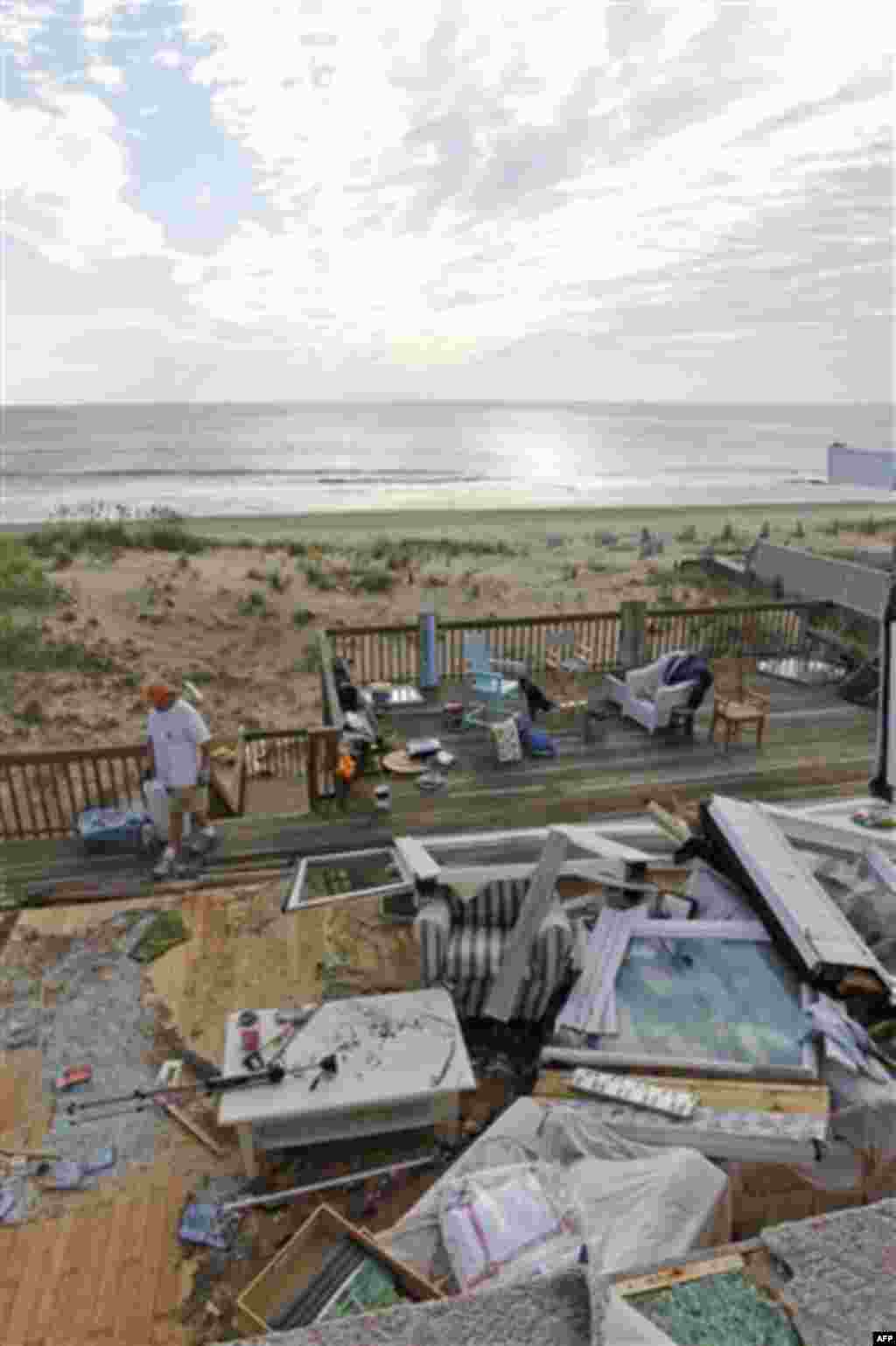 Casey and Denise Robinson clear out their destroyed beach home in the Sandbridge area of Virginia Beach, Va., Sunday, Aug. 28, 2011, the day after Hurricane Irene moved through. Officials speculate that a tornado swept through the area. (AP Photo/Steve He