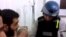 An image grab taken from a video posted by Syrian activists on Aug. 26, 2013 allegdly shows a UN inspector (R) listening to the testimony of a man in the Damascus subburb of Moadamiyet al-Sham.