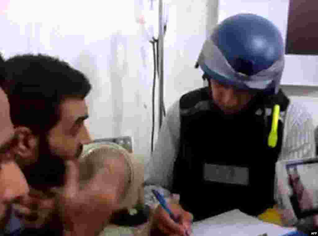 An image grab taken from a video posted by Syrian activists purportedly shows a U.N. inspector speaking to a man in a Damascus suburb, August 26, 2013.